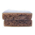 Rectangular block of compressed brown material with a rough, uneven surface texture photographed on a plain background.